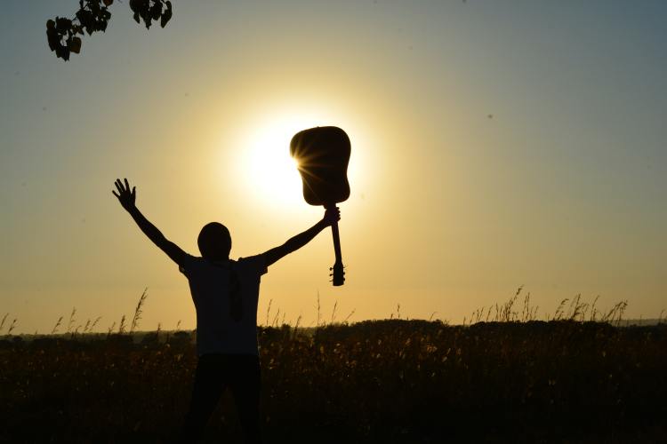 homme avec une guitare dans les mains représentant le musicien